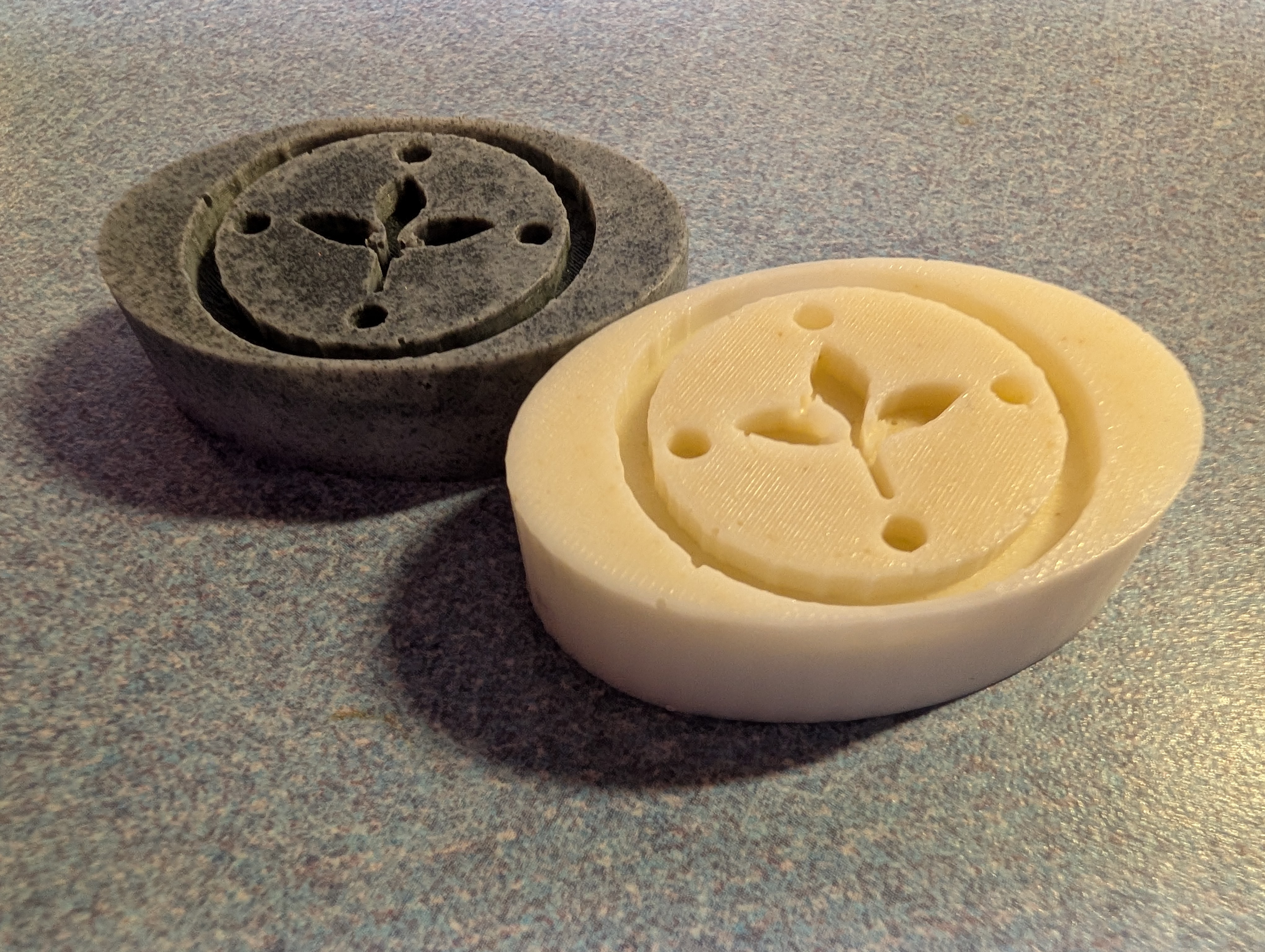 A gentle, unscented, cream-colored facial soap bar with the brand logo, resting on a granite countertop.